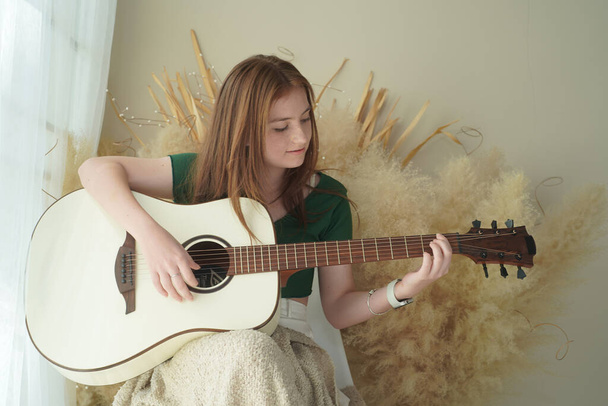 10 代の少女は、アコースティック ギターを弾く - 写真・画像