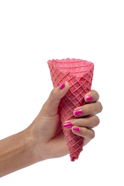Női kéz kezében üres ostya rózsaszín kúp fagylalt. Közelkép, nagy felbontású termék - Fotó, kép