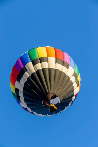 Oslnivé balónky tančí na modré obloze, zářivá podívaná barev radostně plovoucí po nebesích - Fotografie, Obrázek