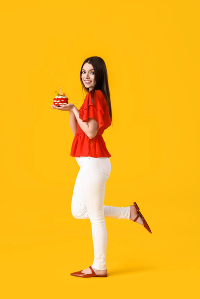Красива молода жінка з солодким тортом на жовтому фоні
 - Фото, зображення