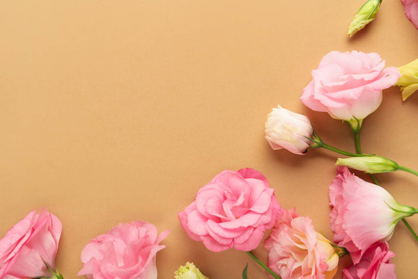 Όμορφα ροζ λουλούδια του ευστώματος σε καφέ φόντο - Φωτογραφία, εικόνα