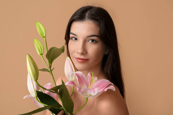 fiatal nő liliom virágok a színes háttér, közelkép - Fotó, kép