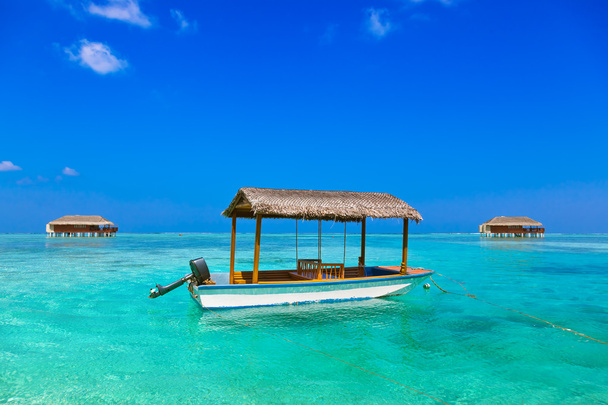 Barco y bungalow en la isla de Maldivas
 - Foto, Imagen
