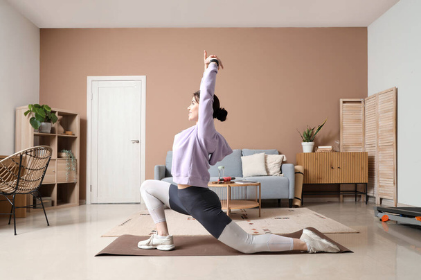 Sportowa młoda kobieta trenuje na macie w domu - Zdjęcie, obraz