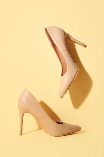Stylish nude high-heeled shoes on color background - Photo, Image