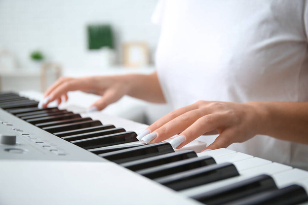 Young woman playing synthesizer at home, closeup - Photo, Image