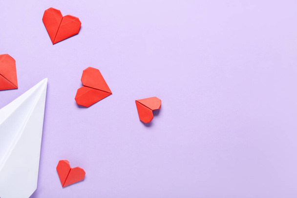 Kağıt uçaklı kompozisyon ve eflatun kaplamalı kırmızı kalpler. Sevgililer Günü kutlaması - Fotoğraf, Görsel