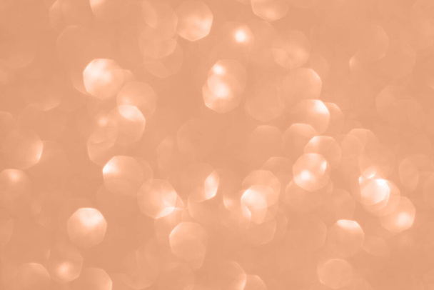 Brzoskwiniowe kolorowe tło z rozmytymi światłami wakacyjnymi. Pokazanie brzoskwiniowego koloru 2024 roku. - Zdjęcie, obraz