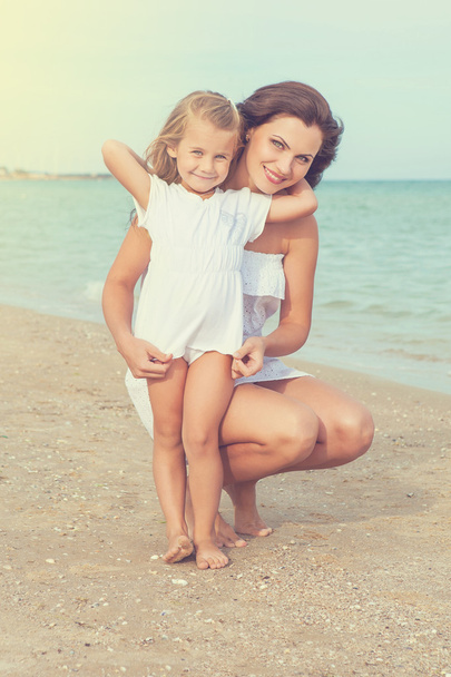 Moeder en haar dochter plezier op het strand - Foto, afbeelding