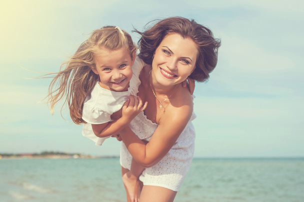Mother and her daughter  having fun on the beach - Photo, image