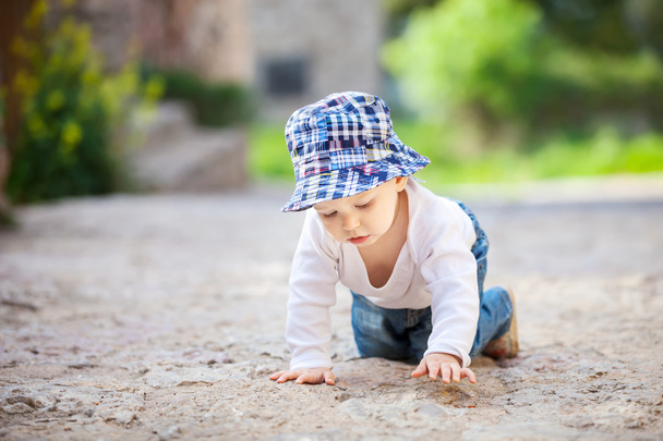 Μικρό αγόρι που σέρνεται πάνω πέτρα πλακόστρωτο πεζοδρόμιο - Φωτογραφία, εικόνα