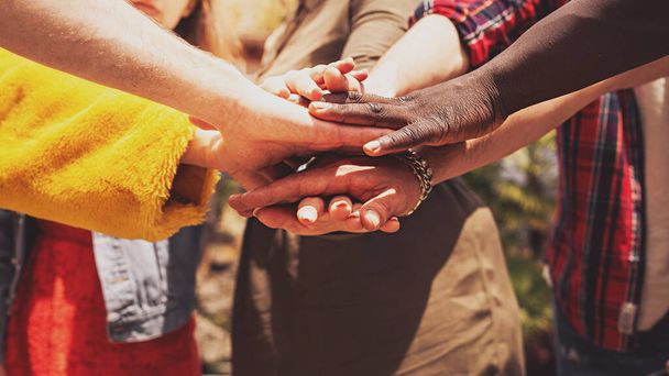 Різноманітні руки об'єднуються в єдність і співпрацю, символізуючи різноманітність і включення. - Фото, зображення