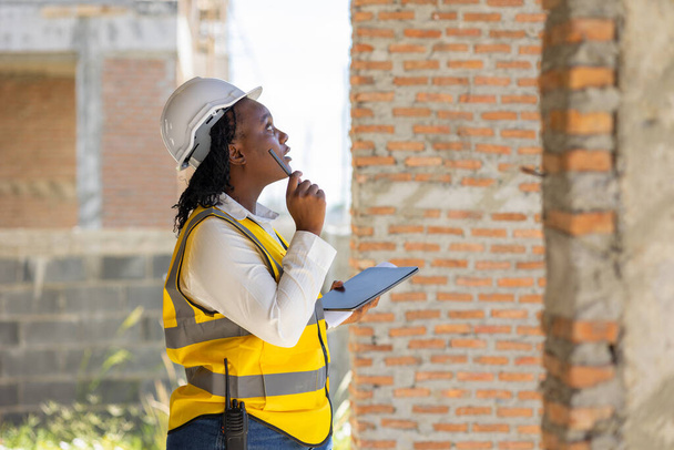 Μηχανικός γυναίκες μαύρος Αφρικανός επαγγελματίας εργαζόμενος που εργάζεται επιθεώρηση ποιοτικός έλεγχος του εργοταξίου οικοδομή έργο. - Φωτογραφία, εικόνα