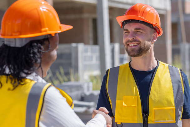 Gelukkige bouwkundig ingenieur handdruk. Builder man geniet van het werken job deal contact met partner team glimlach samen. - Foto, afbeelding