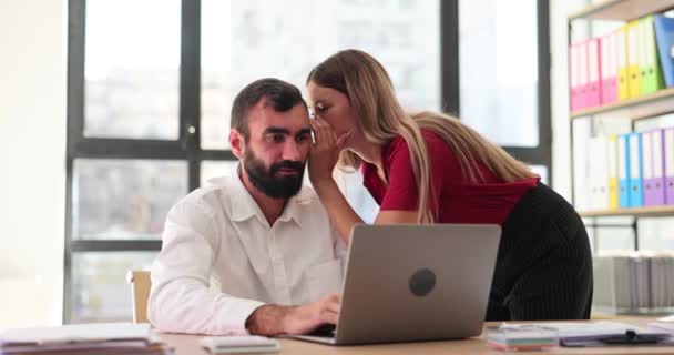 La mujer gerente le susurra secreto a su colega de oficina. Trabajadores chismorreando en la oficina - Metraje, vídeo