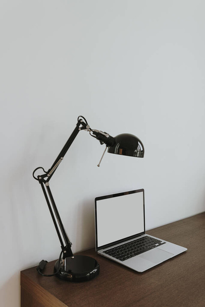 Laptop-Computer mit leerem Kopierraum Bildschirm auf Tisch mit Lampe dekoriert. Ästhetisch minimalistischer Homeoffice-Arbeitsplatz. Online-Shop, Shop-Attrappe Vorlage - Foto, Bild