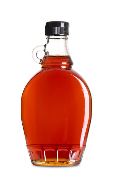 Ahornsirup in einer Glasflasche. Kanadischer Ahornsirup in Flaschen, hergestellt aus dem Saft von Ahornbäumen, in denen Saccharose am häufigsten vorkommt. Verwendung beim Backen, als Gewürz, Süßstoff und Aromastoff. - Foto, Bild