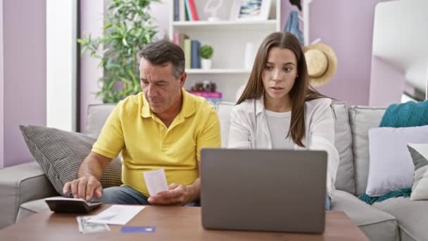 ¡Negocios familiares ganan! sonriente padre e hija sentado en el sofá, chocando los cinco sobre el logro de la contabilidad en casa - Metraje, vídeo