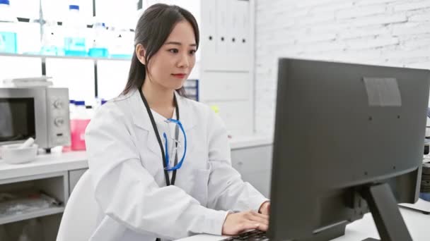 Der glückliche Blick einer jungen chinesischen Wissenschaftlerin weit weg, als die Hand ihre Suche im Labor erleichtert - Filmmaterial, Video