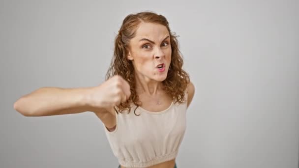 Furious young woman standing enraged, fist clenched in fits of madness. pure anger, frustration from raging fury radiates on an isolated white background. - Footage, Video
