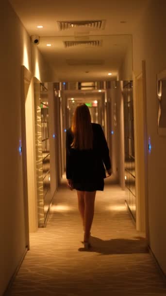 uma jovem mulher em um vestido preto curto entra em seu quarto de hotel - Filmagem, Vídeo