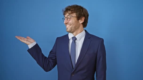 Veselý mladý muž v obleku sebevědomě ukazující ok gesto s dlaní, šťastné palce nahoru na izolovaném modrém pozadí, spokojeně se usmívající. - Záběry, video