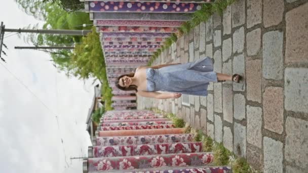 Vidám spanyol nő szemüvegben örömteli sétát tesz Kiotó híres kimonó erdejében, ragyogó mosolyával a kamera előtt. - Felvétel, videó