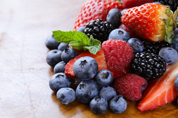 Berry assortment - raspberries, blackberries, strawberries, blueberry on a wooden background - Zdjęcie, obraz