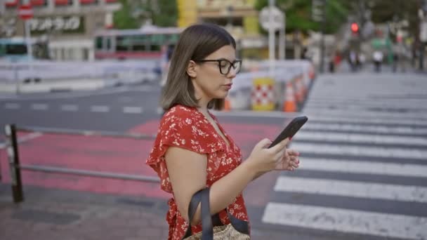 Στους πολυσύχναστους δρόμους του Τόκυο, ένα όμορφο ισπανόφωνο κορίτσι με γυαλιά, ένα έμπειρο ταξιδευτή, χρησιμοποιεί την εφαρμογή του τηλεφώνου της, περιμένοντας με αγωνία τη βόλτα της με ταξί.. - Πλάνα, βίντεο