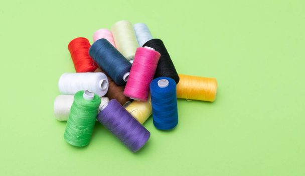 Verschillende spoelen van naaigarens van katoen van verschillende kleuren op gekleurde achtergrond - Foto, afbeelding