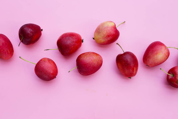 Čerstvé malé červené jablka na růžovém pozadí - Fotografie, Obrázek