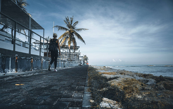 Egy nő sétál Kuta strandján reggel.. - Fotó, kép