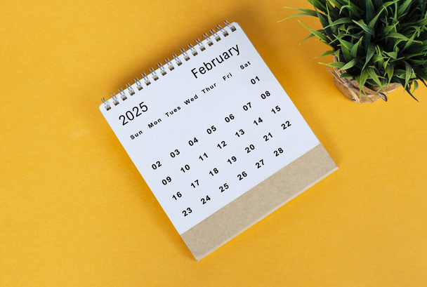 February 2025 desk calendar on yellow background. Directly above. Flat lay. Copy space. - Photo, Image