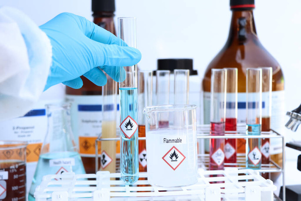 Camdaki kimyasalların yanıcı sembolleri, laboratuvardaki kimyasallar veya endüstrideki kimyasallar - Fotoğraf, Görsel