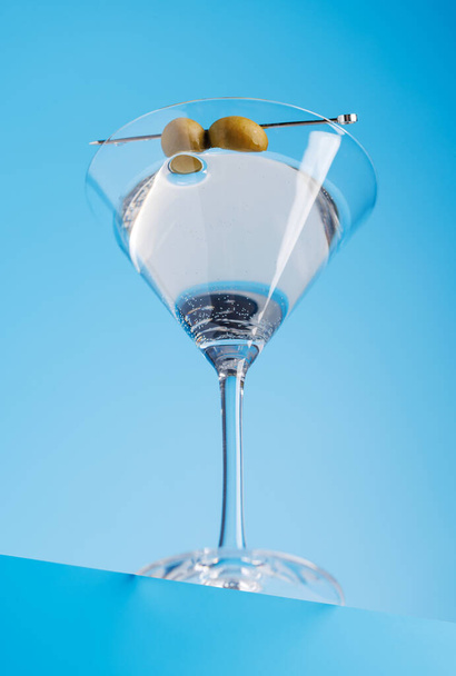 Cocktail delight: Классический мартини на прохладном синем фоне - Фото, изображение