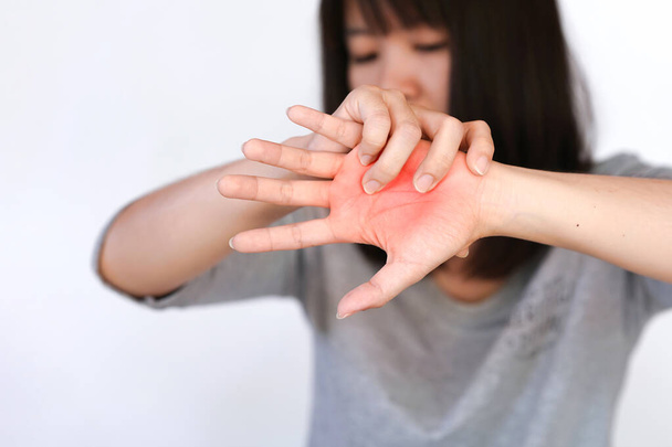 Žena se dotkne dlaně červenou oblastí, aby naznačila bod bolesti.. - Fotografie, Obrázek