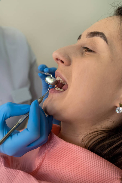 Biała młoda kobieta na wizycie u dentysty sprawdza zęby i dziąsła, zapobiega próchnicy - Zdjęcie, obraz