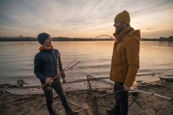 Father and son are ready for fishing on winter day. Freshwater fishing. - Фото, изображение