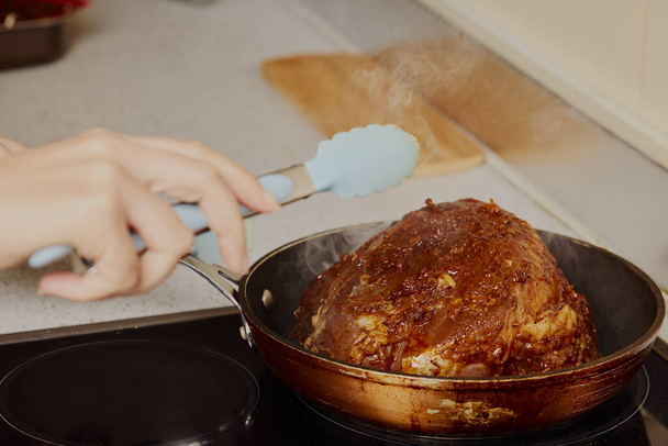 Stuk varkensnek in een pan op een elektrisch fornuis. - Foto, afbeelding