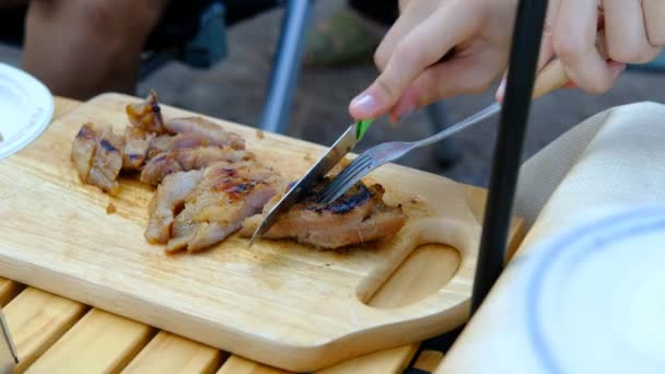 Mains féminines coupant la viande sur une planche à découper en bois - Séquence, vidéo