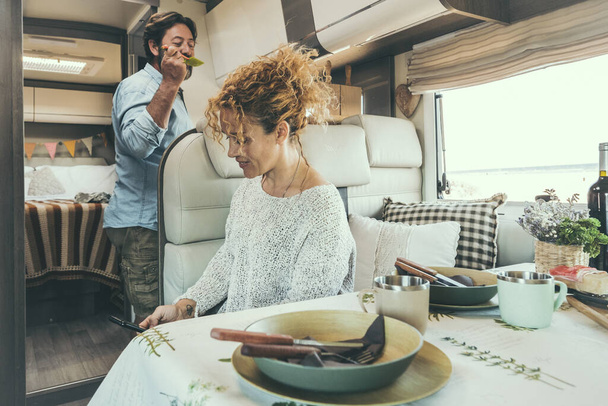 Couple en camping-car relaxant préparer le déjeuner et profiter du temps libre - Photo, image