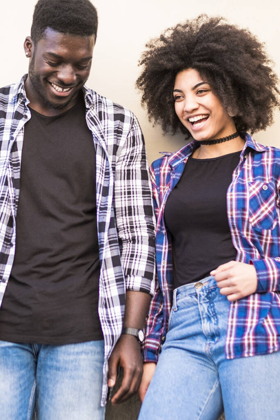 heureux noir hipster jeune couple profiter ensemble loisirs en plein air dans la ville avec mur en arrière-plan  - Photo, image