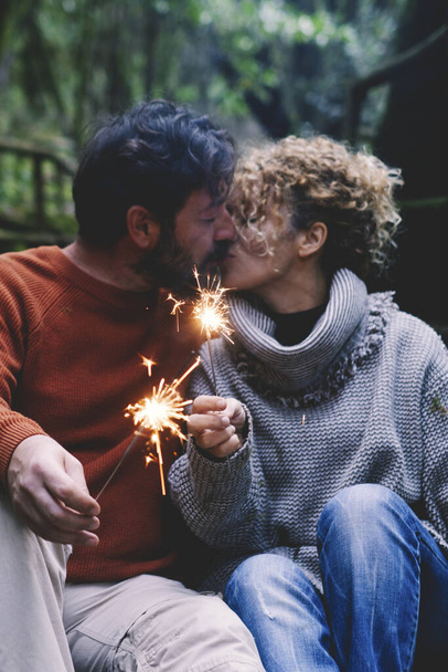 Romantický dospělý pár líbání v lásce drží oheň jiskry sedí v přírodním parku těšit venkovní vztah a volnočasové aktivity společně. Koncept šťastných lidí, kteří si užívají dovolenou v horách - Fotografie, Obrázek