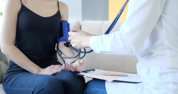 El médico mide la presión arterial del paciente en casa. Control de la presión arterial en cardiopatías - Imágenes, Vídeo