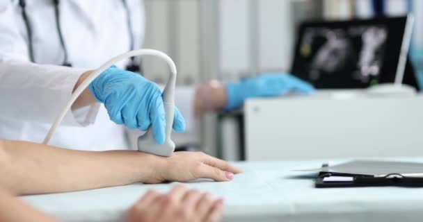 De dokter doet ultrasoon onderzoek van patiëntenhanden. Pijn in armen en handen diagnose en behandeling concept - Video