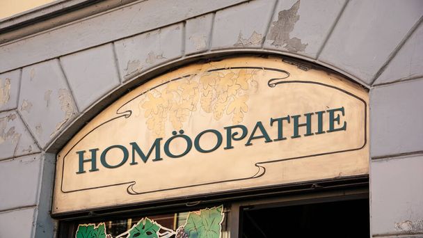 Kuvassa on kyltti ja merkki, joka osoittaa homeopatian suuntaan saksaksi.. - Valokuva, kuva