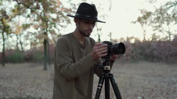 Arabic stylish man taking photo of landscape and nature with modern camera on tripod. Copy space - Footage, Video