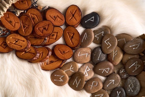 Handgefertigte Runen aus Holz und Stein auf weißem Fell - Foto, Bild