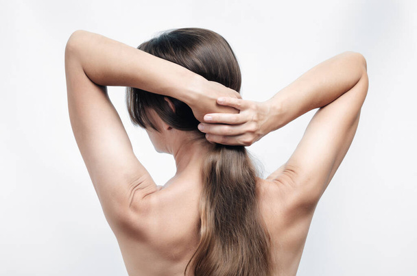風呂の後ろから髪を引っ張るヌードの女性 - 写真・画像