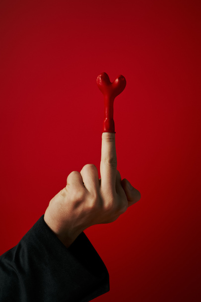 disparo recortado de hombre provocativo mostrando el dedo medio con globo sobre fondo rojo, 14 Febrero - Foto, imagen